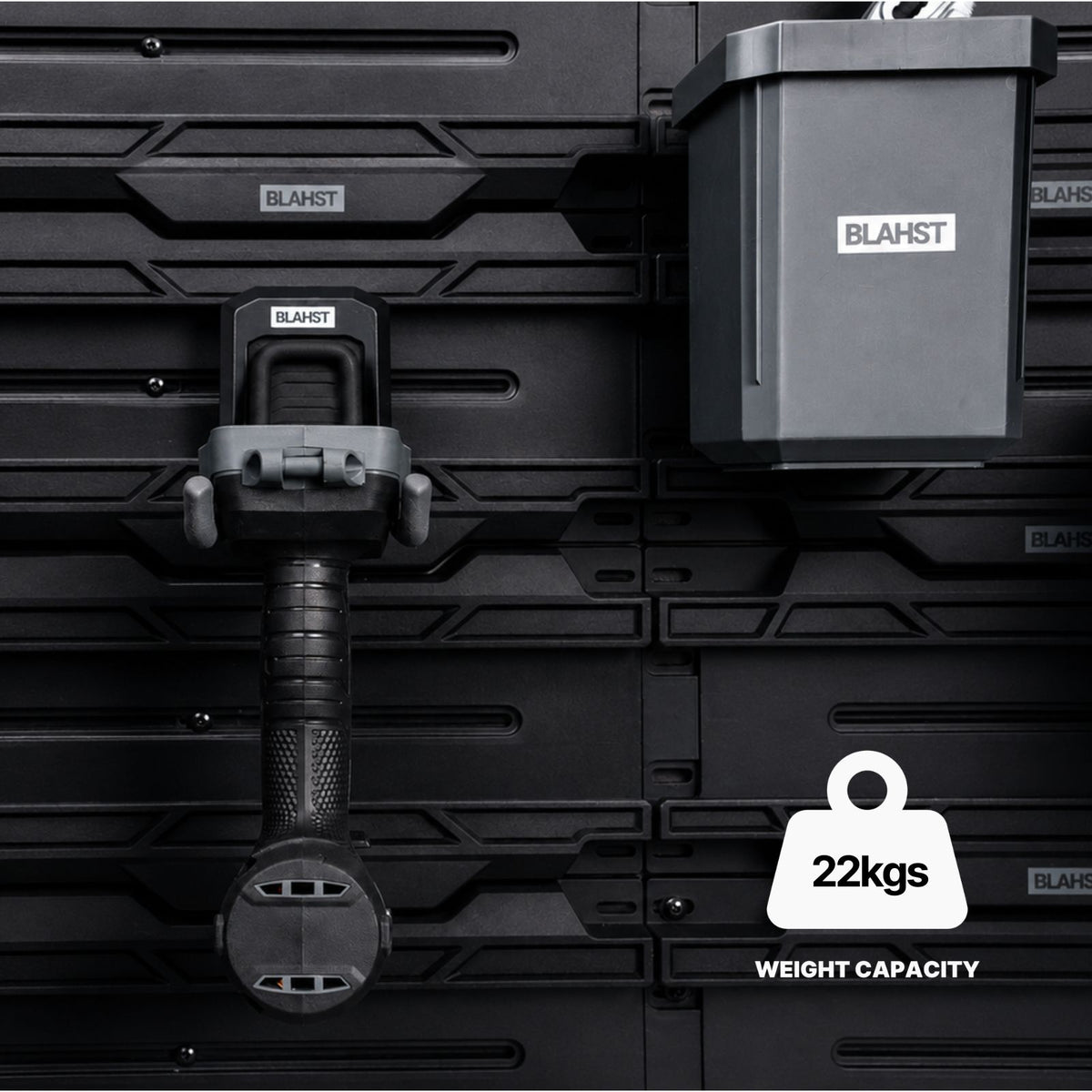 Close-up of a BLAHST Modular Power Tool Hook and tub mounted on a rail holding a tool handle