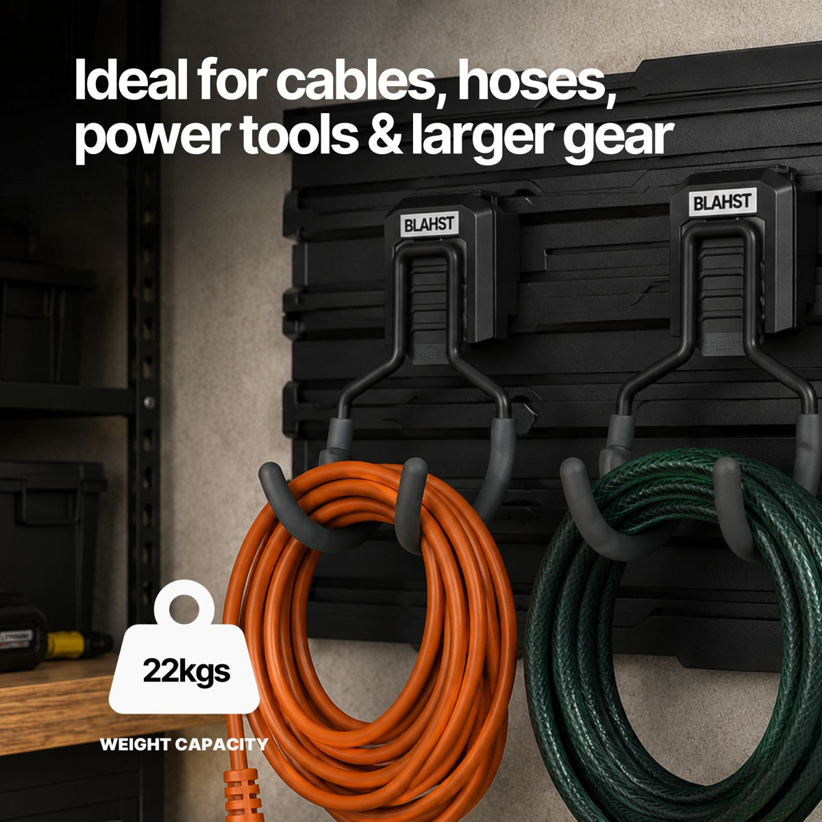 Orange and green coiled cables hanging from two BLAHST Modular Curved Hooks on a wall panel