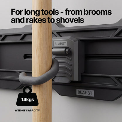 Broom handle hanging from a BLAHST Modular S Hook mounted on a garage wall rail