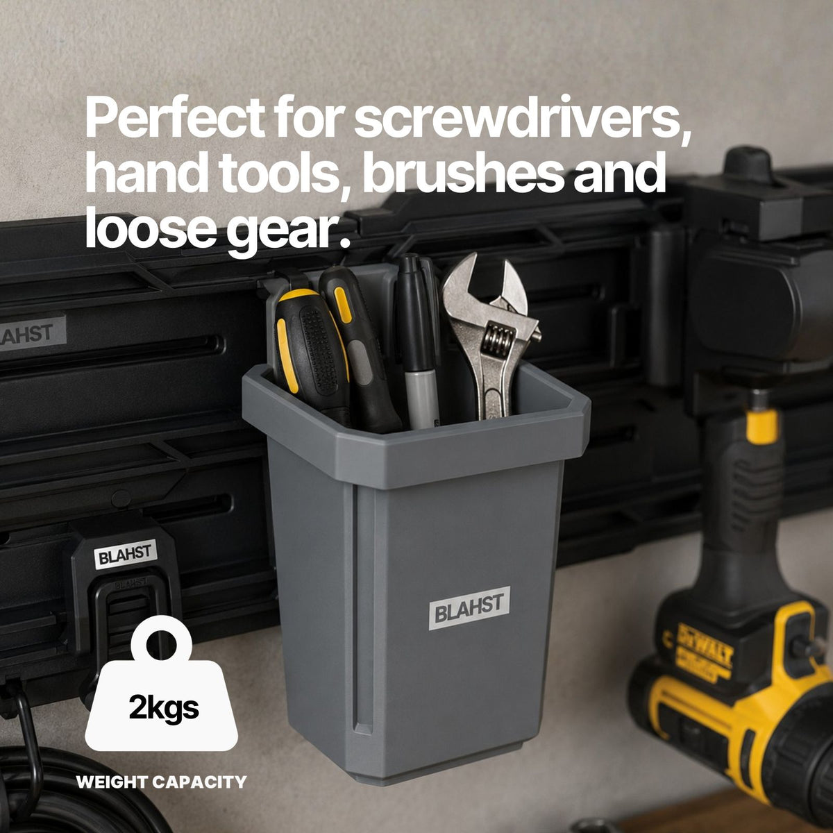 Screwdrivers and a wrench stored in a BLAHST Modular Single Tub mounted on a garage wall rail