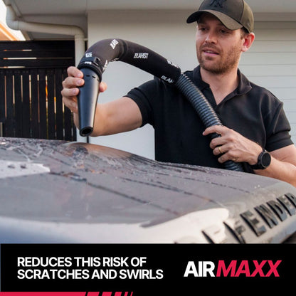 Man drying a 4WD wheel with a BLAHST Air Maxx Dryer in a driveway