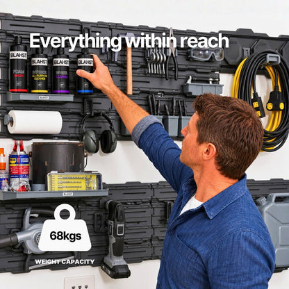 Man reaching for BLAHST cleaning bottles stored on a BLAHST Modular wall rail system in a garage